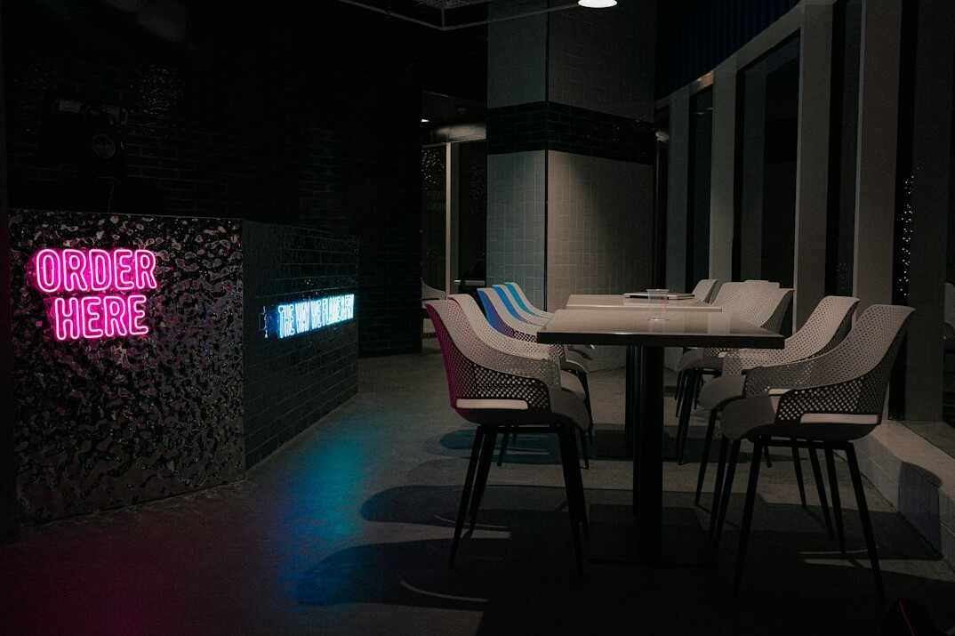 Modern television broadcast studio with colourful LED lighting and presenter desk