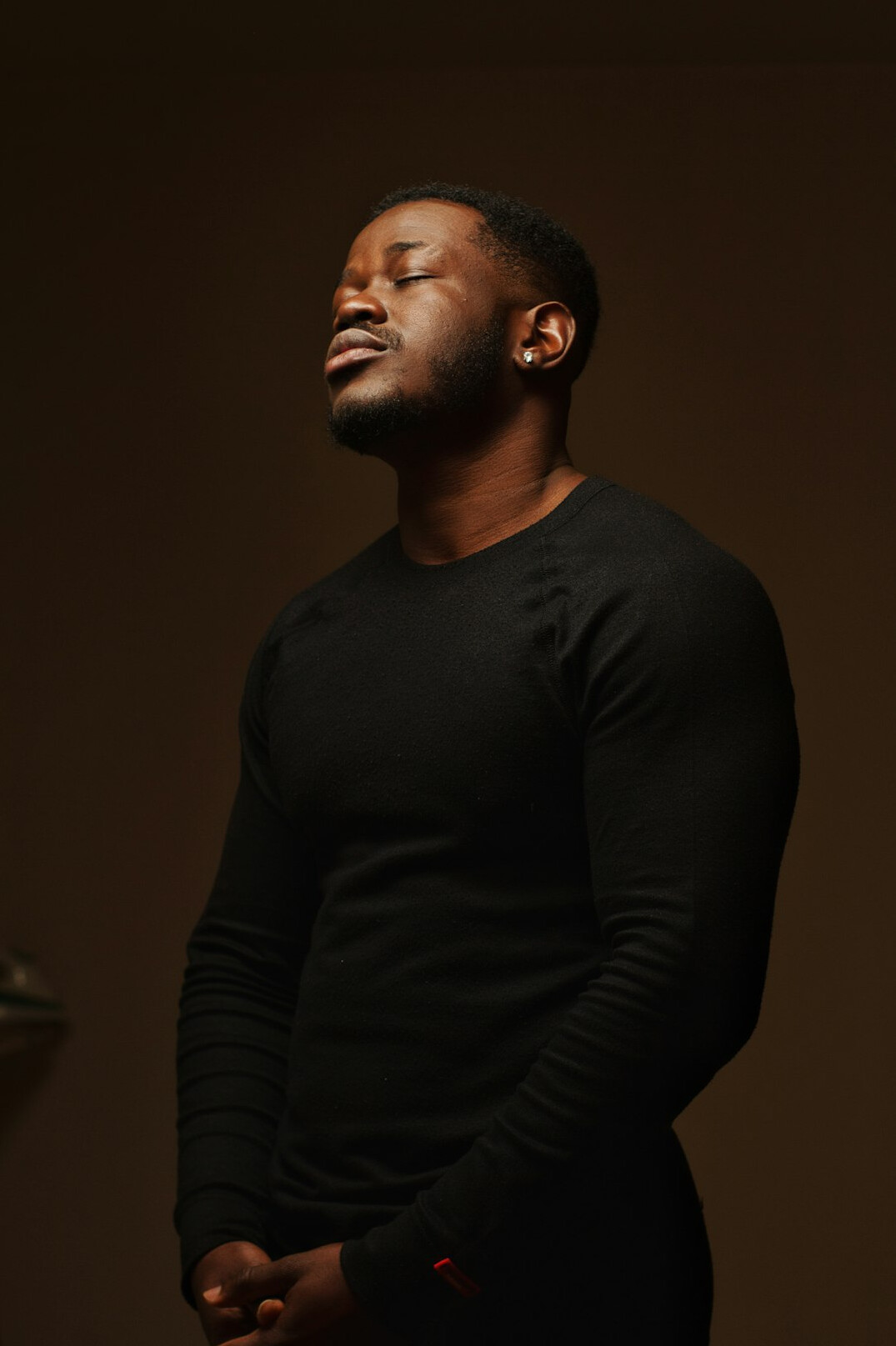 Portrait of a smiling Black man with short hair wearing a dark shirt